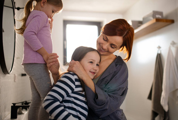 Mother hugging her little daughter in bathroom at home. - Fotografie, Obrázek
