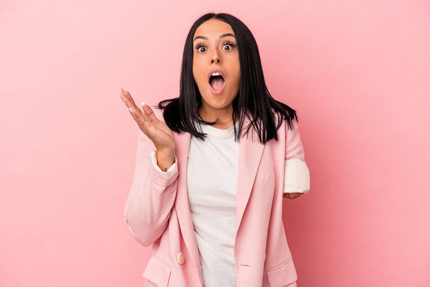 Young caucasian woman with one arm isolated on pink background surprised and shocked. - Foto, immagini