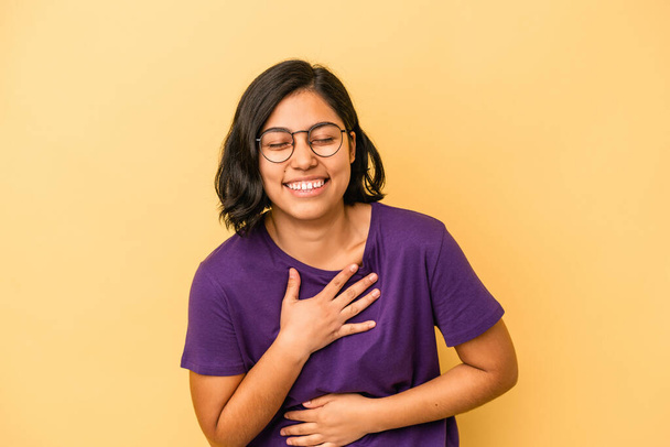 Mladá latinská žena izolovaná na žlutém pozadí, smějící se ruce na srdci, koncept štěstí. - Fotografie, Obrázek