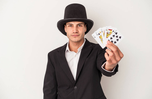 Joven mago caucásico sosteniendo unas cartas mágicas aisladas sobre fondo blanco - Foto, imagen