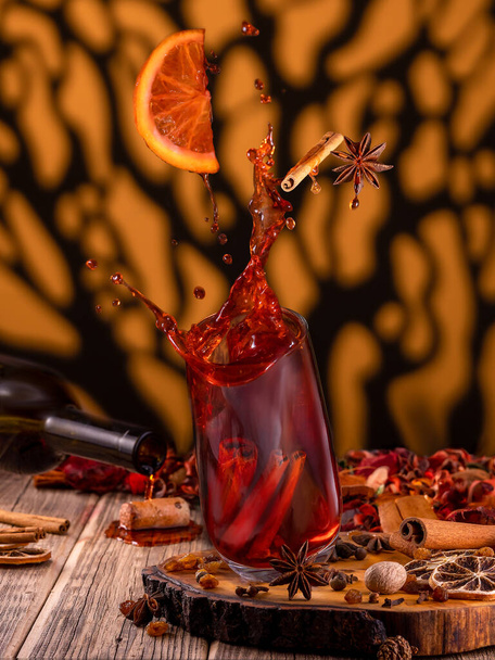 Preparation of mulled wine from wine. Splashes of wine, falling glass - Фото, изображение