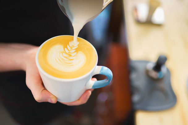 barista pouring milk into espresso coffee for making cappuccino, latte art - Φωτογραφία, εικόνα