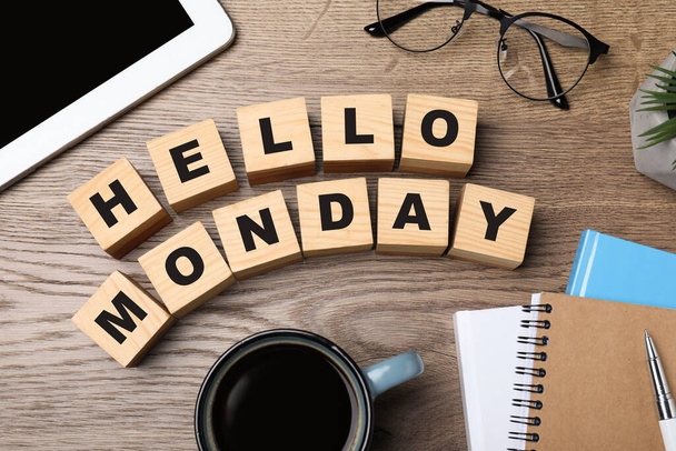 Cubes with message Hello Monday, office stationery and cup of coffee on wooden desk, flat lay - Valokuva, kuva