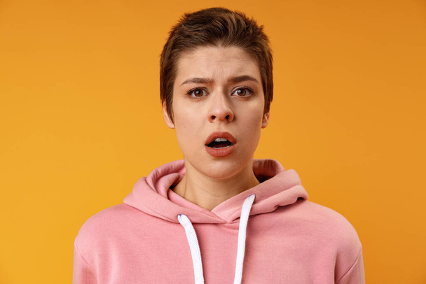 Surprised young woman shouting over yellow background - Photo, Image