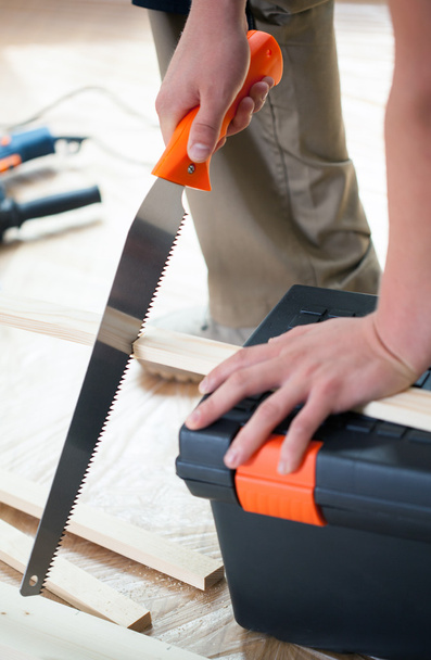 Cutting wooden plank with hand saw - Фото, зображення