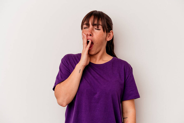 Jovem argentina isolada no fundo branco bocejando mostrando um gesto cansado cobrindo a boca com a mão. - Foto, Imagem