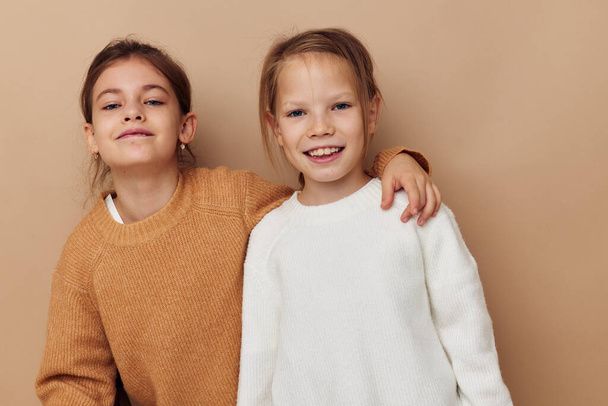 two cute little girls hug friendship lifestyle beige background - Foto, imagen