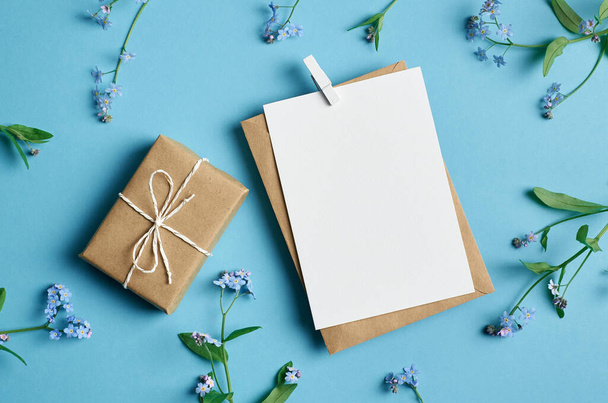 Greeting card mockup with gift box on blue - Zdjęcie, obraz