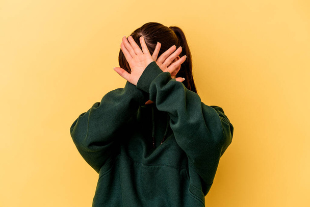 Giovane donna argentina isolata su sfondo giallo tenendo due braccia incrociate, concetto di negazione. - Foto, immagini