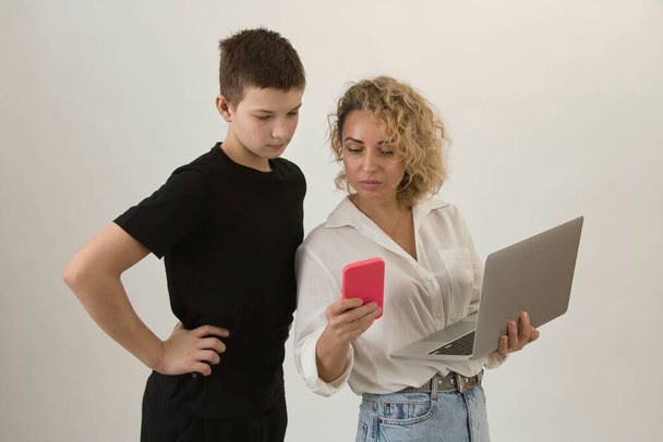 A teacher with a laptop explains a task to a teenage student. Close up, white background. - Photo, Image
