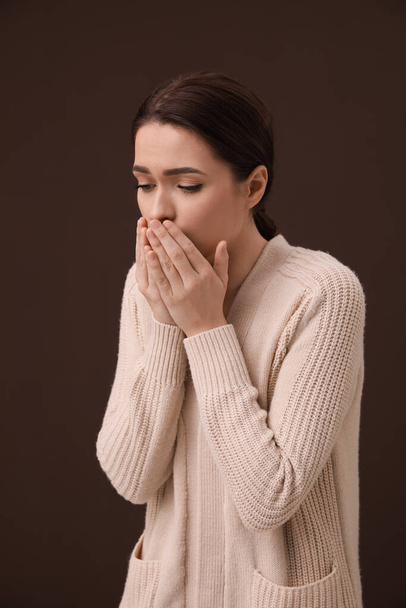 Woman coughing on brown background. Cold symptoms - Photo, Image