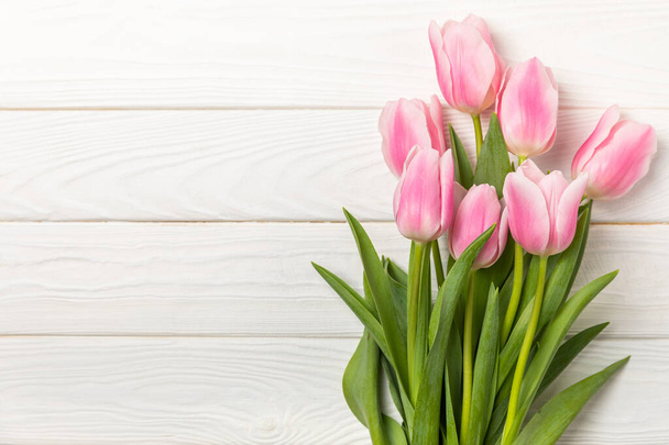 Pink tulips on a white wooden background.Top view. Spring bouquet.Holiday concept.Women's day, Valentine's day,Easter, birthday.Copy space. - Foto, imagen
