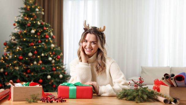 Young woman with beautifully wrapped Christmas gift at home - Foto, Imagem