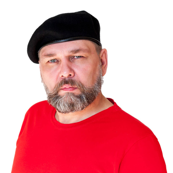 Серйозна людина. Управління середнього віку з сірою бородою в червоній футболці та чорному береті, ізольовано на білому
. - Фото, зображення
