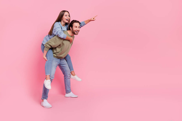 Full size profile photo of excited positive two persons look direct finger empty space isolated on pink background - Foto, Imagen