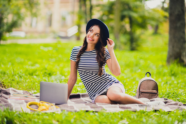 Portrait of beautiful dreamy cheerful schoolgirl doing home task work project sitting on cover on fresh air outdoors - Φωτογραφία, εικόνα