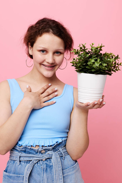 portrait of a young woman potted flower posing plant pink background unaltered - Foto, Imagen