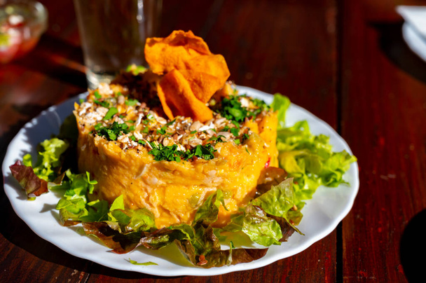 Ужин в гуачинче, типичном канарском заведении на Тенерифе, где местное производство белого или красного вина сопровождается домашней традиционной едой в солнечный день, сладкий картофельный салат с зеленым салатом - Фото, изображение