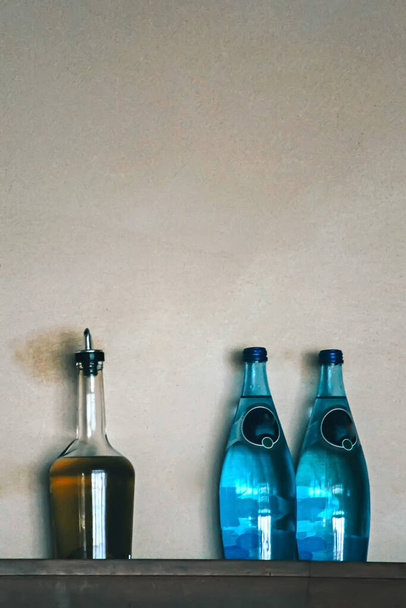 lähikuva juomista harmaalla seinällä olevissa pulloissa - Valokuva, kuva