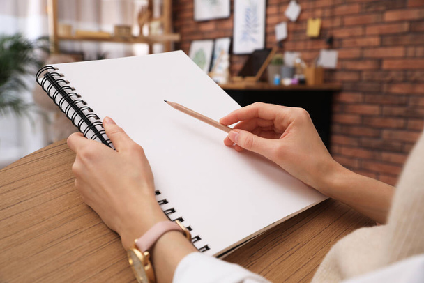 Dibujo de mujer en cuaderno de dibujo con lápiz en casa, primer plano - Foto, imagen