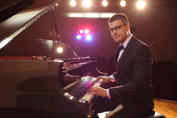 Young handsome male pianist on stage looking at camera - Foto, imagen