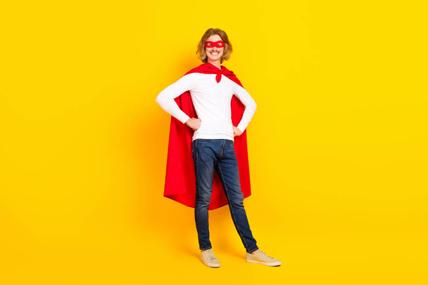 Photo of confident funky guy dressed white shirt superman clothes arms waist isolated yellow color background - Fotoğraf, Görsel
