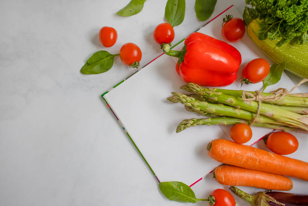 σημειωματάριο, λαχανικά και φρούτα σε ελαφρύ φόντο, σχέδιο διατροφής - Φωτογραφία, εικόνα