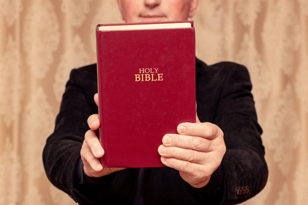 Un hombre en oración con una Biblia en la mano - Foto, imagen