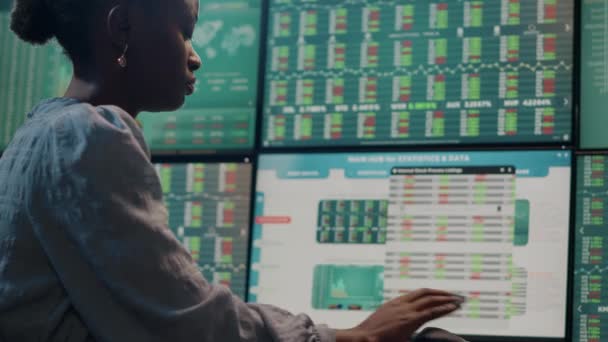 Brokerinnen betrachten Multi-Monitore mit Devisenbörsenstatistiken - Filmmaterial, Video