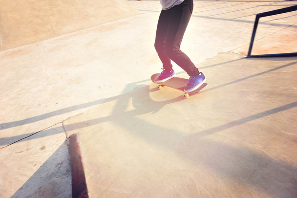 Skateboarding woman legs at sunrise - 写真・画像