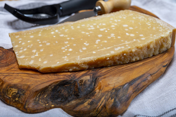 72 months very old Italian parmigiano-reggiano parmesan cheese from Parma has amber color, dry, extremely grainy and crumbly with very intense taste, close up - Фото, зображення