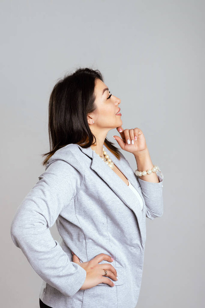 Full length portrait of smiling attractive businesswoman in suit posing while standing with arms crossed and looking at camera isolated over white background - Photo, Image