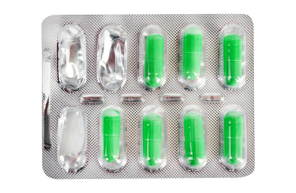 Изолированное фото использованных зеленых таблеток волдырь на белом фоне. - Фото, изображение
