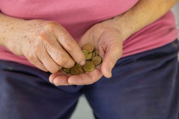 Eine alte Frau zählt kleines Geld. Selektiver Fokus. Menschen. - Foto, Bild