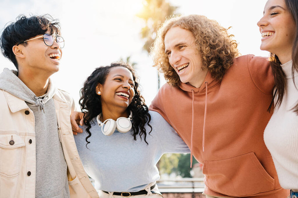Gruppe fröhlicher junger, unterschiedlicher Teenager-Freunde lacht gemeinsam im Freien - Foto, Bild