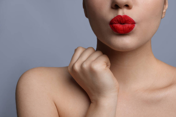 Closeup view of beautiful woman puckering lips for kiss	on grey background - Valokuva, kuva