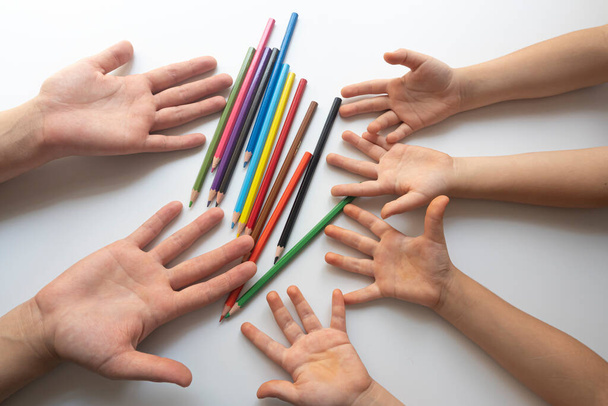 Crayons and four children's hands on a white background. education concept.Concept of kinder education during the pandemic period. - Photo, Image
