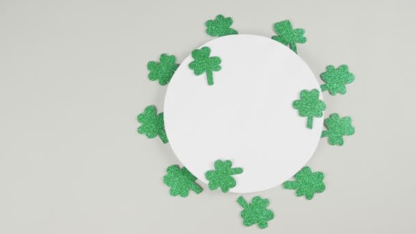 St. Patricks Day shamrocks op een grijze achtergrond. Zicht van bovenaf. Begrepen, ruimte. 4K - Video