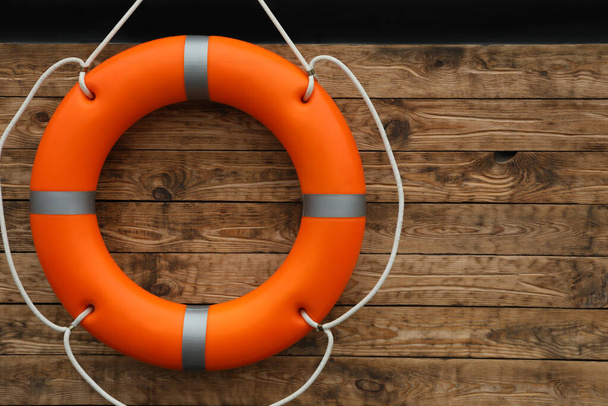 Orange lifebuoy hanging on wall, space for text. Rescue equipment - Фото, зображення