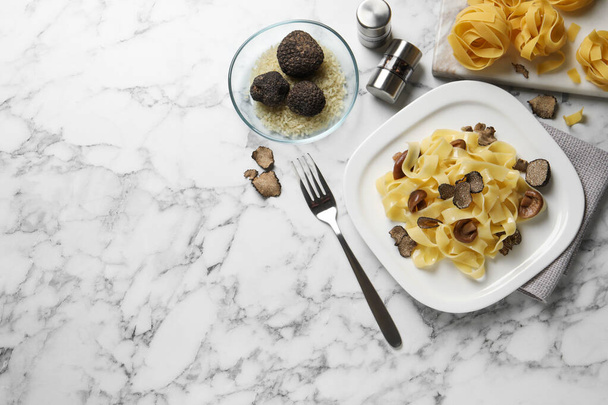 Tasty tagliatelle with truffle served on white marble  table, flat lay. Space for text - Foto, Imagen