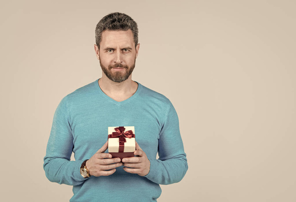 handsome mature man with beard holding present box, copy space, giftbox - Фото, изображение