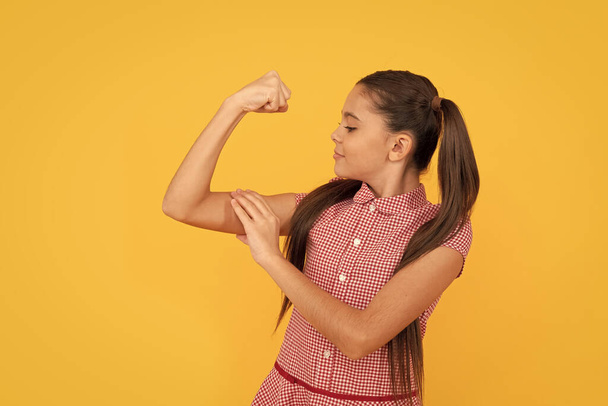 Girl power. Female child flex arm yellow background. Gesture of power and strength. CRL PWR - Photo, Image