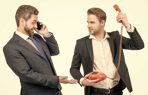 Geschäftsmann mit Handy sieht Mann mit Telefon an. Mobil- und Telefonkommunikation - Foto, Bild