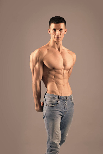 Spierfitness. Fit man poseren shirtloos. Bodybuilder met spiermassa. Lichamelijke geschiktheid en sport - Foto, afbeelding