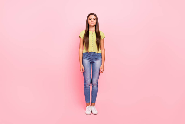Photo of positive cute cheerful little lady posing wear green top jeans footwear isolated pink color background - Fotoğraf, Görsel