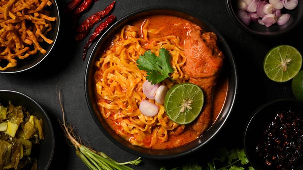 Tasty northern Thai food concept, Khao Soi Kai or creamy and slightly spicy yellow curry served with chicken drumstick and egg noodles. Thai restaurant cuisine. - Photo, Image