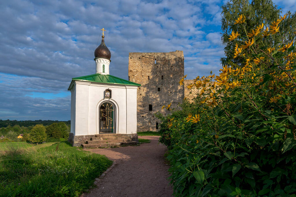 タラフスカヤ塔と晴れた夏の日にイズボルスク要塞の壁の背景に神の母のコルサンスカヤアイコンの礼拝堂の眺め,イズボルスク,プスコフ地域 - 写真・画像