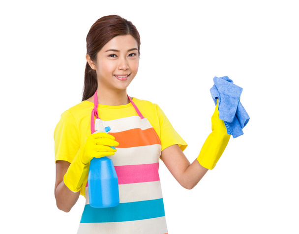 huisvrouw met behulp van spray en handdoek - Foto, afbeelding