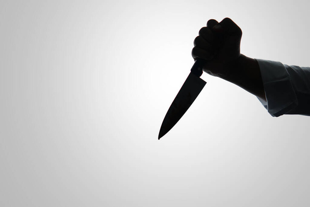 silhouette of criminal hand holding knife on white background, cut out - Photo, Image