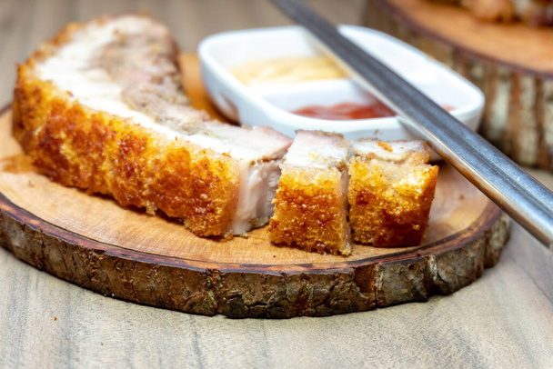 Christpy Pork Belly Roast, Hong Kong and Asian Style, Whole and Chopped (англійською). Цей вид смаженої свинини відомий своєю хрусткою текстурою шкіри, в той час як м'ясо залишається м'яким з сумішю жиру. - Фото, зображення